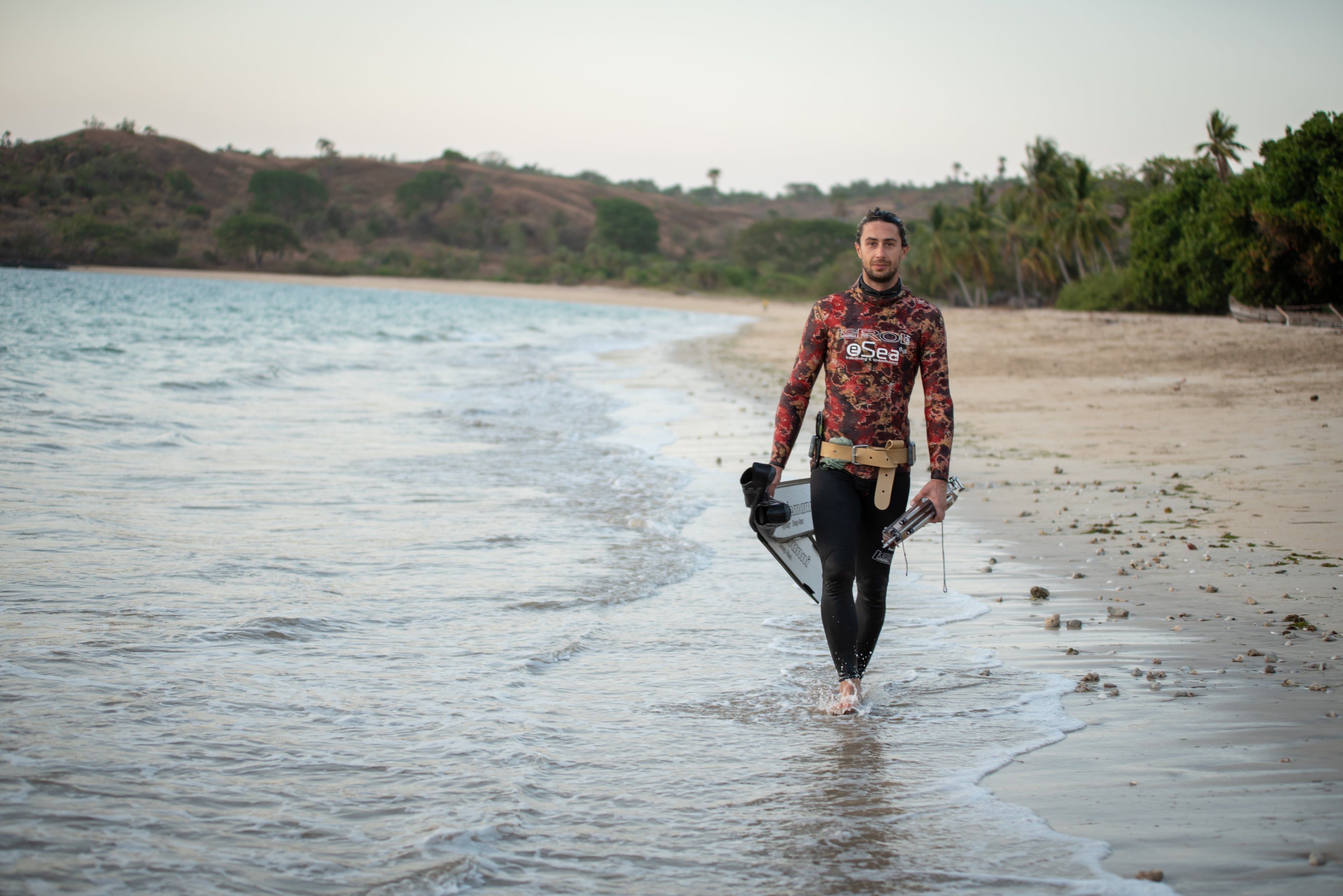 Giovanni Bianco walking along the beach, embodying his deep connection to the ocean and his lifelong passion for spearfishing